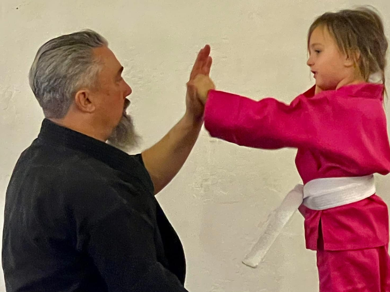 Martial arts instructor giving a young student a high five