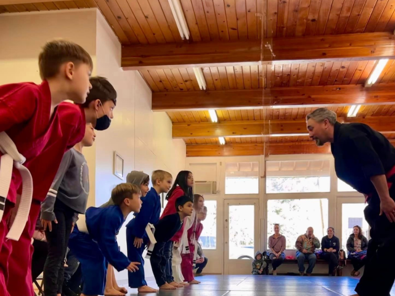 Elevate Martial Arts students bowing to their instructor on the mat